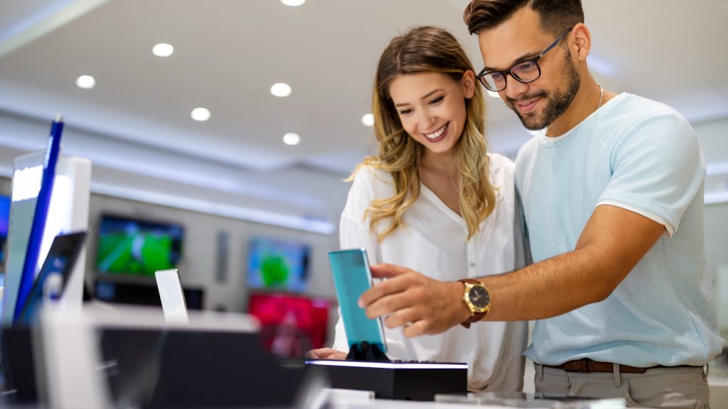 Couple consultant des téléphones dans un magasin